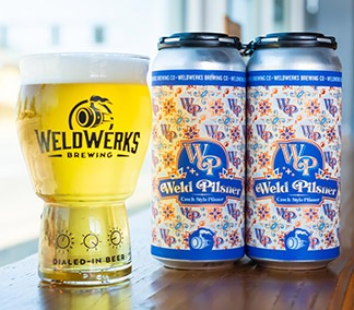 Glass and cans of WeldWerks Weld Pilsner.